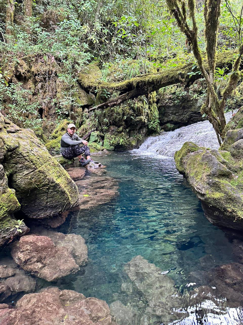 Río de agua cristalina turquesa entre rocas cubiertas de musgo en la Reserva El Cielo, Tamaulipas