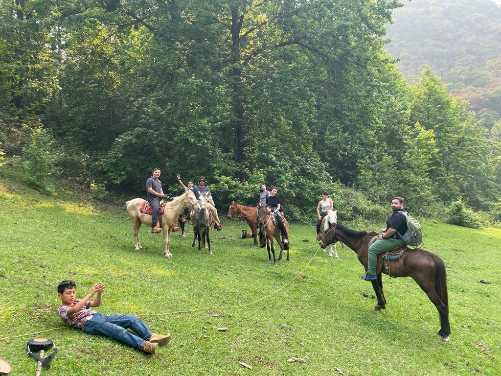 Grupo de visitantes a caballo en una pradera rodeada de bosque en El Cielo, Tamaulipas